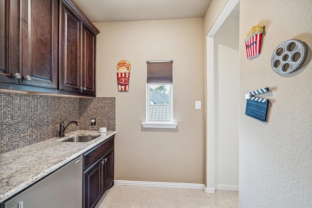 kitchen with tasteful backsplash, dark brown cabinetry, sink, and light carpet