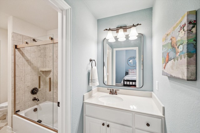 full bathroom with enclosed tub / shower combo, vanity, and toilet