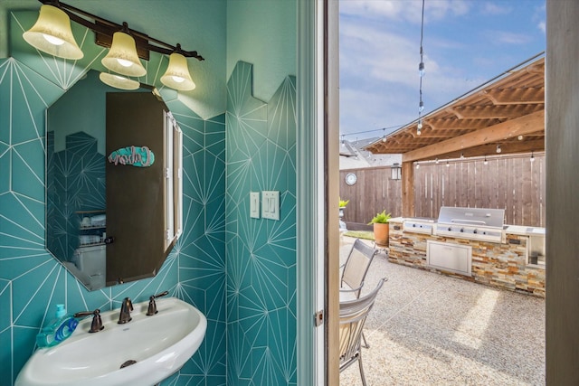 bathroom featuring tile walls and sink