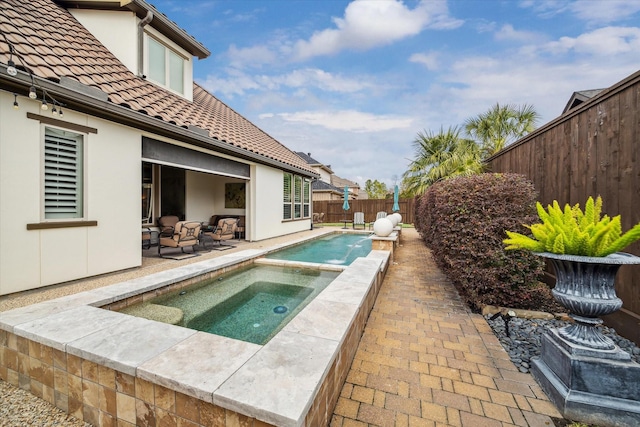 view of pool featuring an in ground hot tub, pool water feature, and a patio area