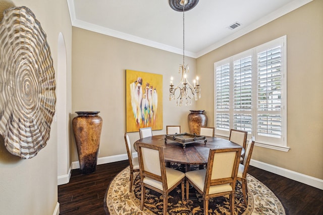 dining space with ornamental molding, dark wood-type flooring, and a notable chandelier