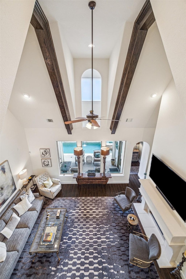 living room featuring beamed ceiling, plenty of natural light, and hardwood / wood-style flooring