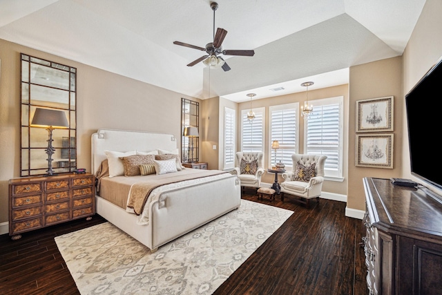 bedroom with ceiling fan with notable chandelier, dark hardwood / wood-style floors, and vaulted ceiling