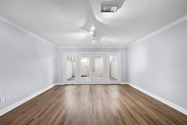 spare room with french doors, ornamental molding, wood-type flooring, and a textured ceiling