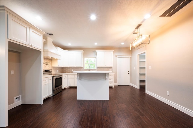 kitchen with custom exhaust hood, dark hardwood / wood-style floors, a kitchen island, stainless steel electric stove, and backsplash