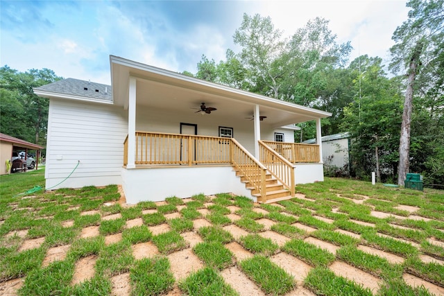 rear view of house with ceiling fan and a yard