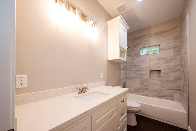 full bathroom featuring vanity, toilet, tiled shower / bath combo, and wood-type flooring