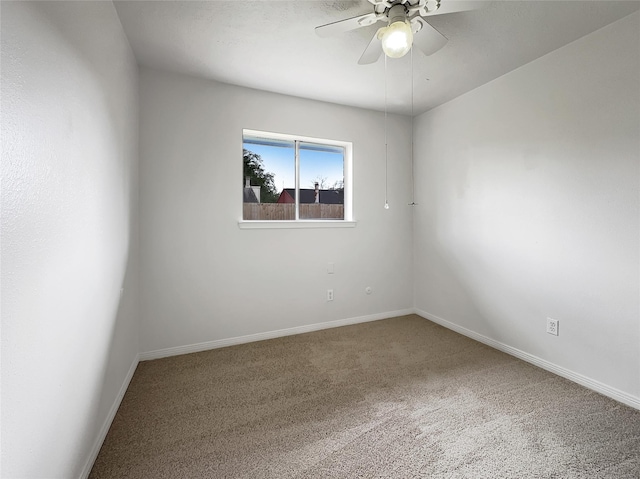 carpeted spare room featuring ceiling fan