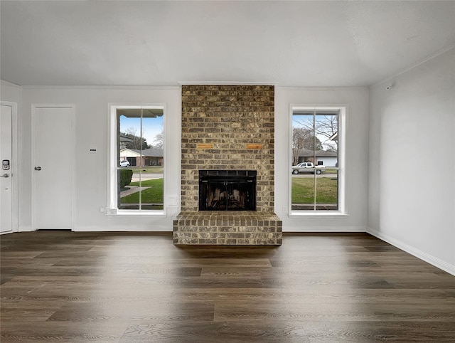 unfurnished living room with crown molding, dark hardwood / wood-style floors, and a brick fireplace