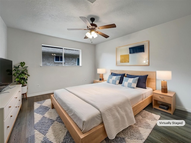 bedroom with dark wood-type flooring, ceiling fan, and a textured ceiling