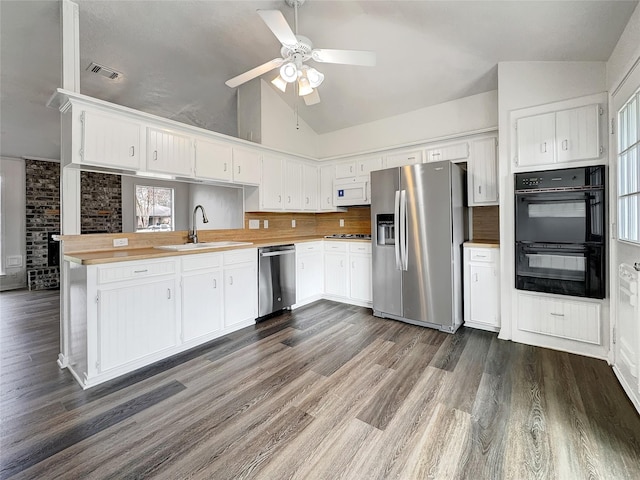 kitchen with black appliances, white cabinetry, lofted ceiling, dark hardwood / wood-style flooring, and kitchen peninsula