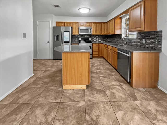 5210 3rd St, Danbury, TX 77534 - kitchen featuring appliances with stainless steel finishes, a sink, baseboards, backsplash, and a center island