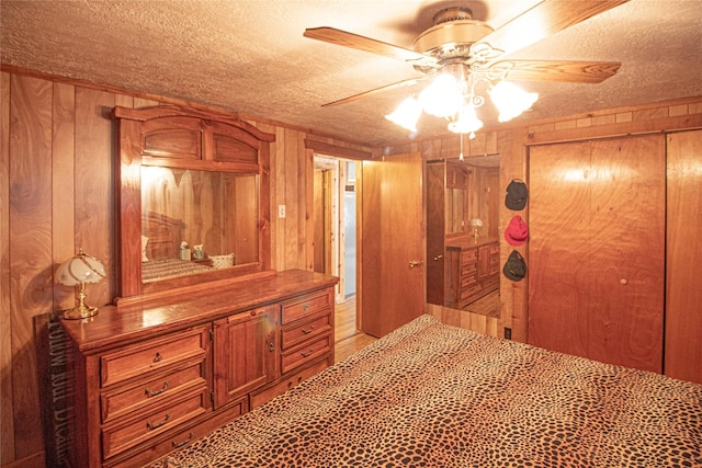 hall with a textured ceiling and wood walls