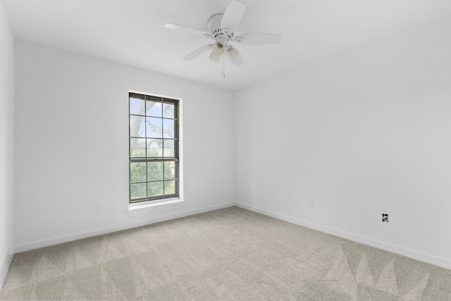 empty room featuring ceiling fan and light colored carpet