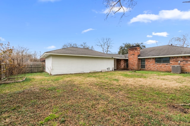 rear view of property featuring a yard and central AC unit