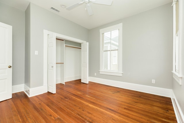 unfurnished bedroom featuring ceiling fan, wood-type flooring, and a closet