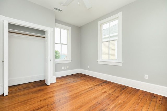 unfurnished bedroom with hardwood / wood-style floors, a closet, and ceiling fan