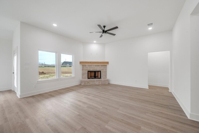 4974 County Road 128, Iola, TX 77861 - unfurnished living room featuring light hardwood / wood-style flooring, a fireplace, and ceiling fan