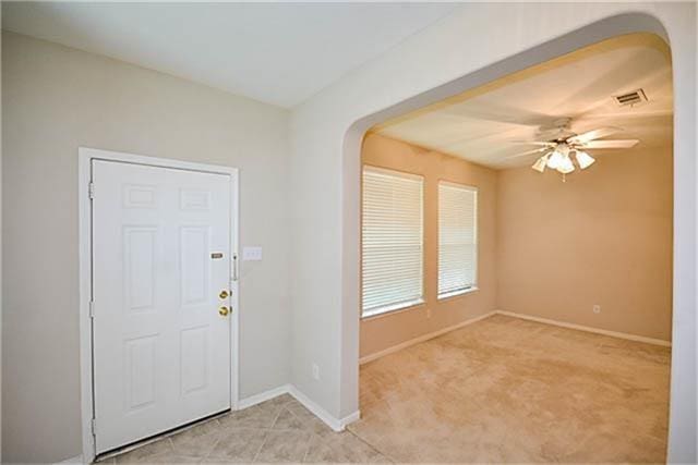 entryway featuring light carpet and ceiling fan