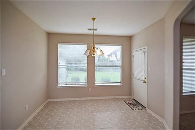 unfurnished dining area with a chandelier