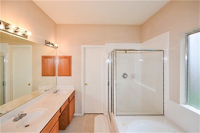 bathroom featuring vanity and shower with separate bathtub