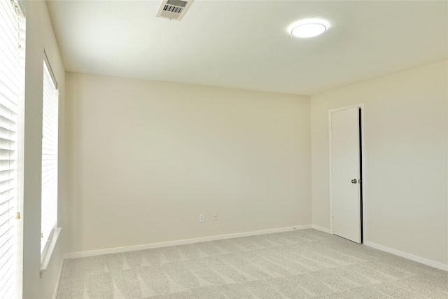 unfurnished room featuring a healthy amount of sunlight and light carpet