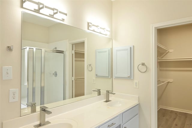 bathroom with wood-type flooring, an enclosed shower, and vanity