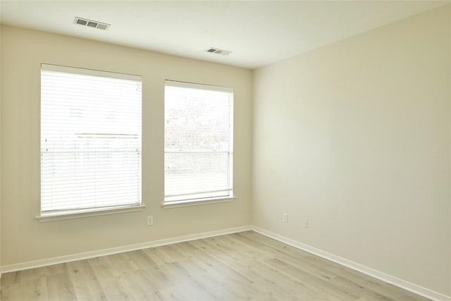 unfurnished room featuring a healthy amount of sunlight and light hardwood / wood-style flooring