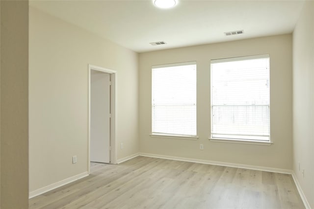 empty room with a wealth of natural light and light wood-type flooring