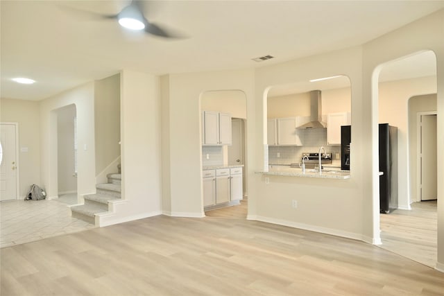 living room with ceiling fan, sink, and light wood-type flooring