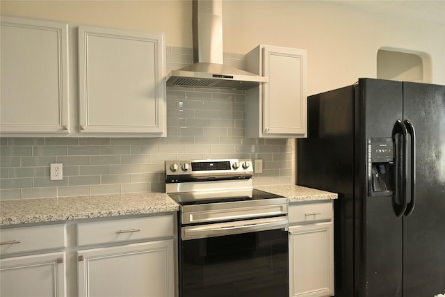 kitchen with tasteful backsplash, white cabinets, stainless steel range with electric cooktop, black fridge, and wall chimney range hood