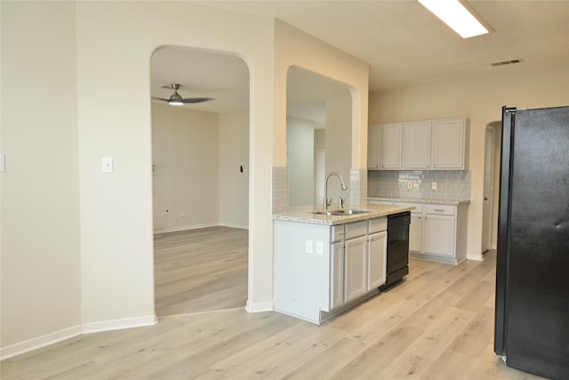 kitchen featuring white cabinetry, sink, backsplash, and black appliances