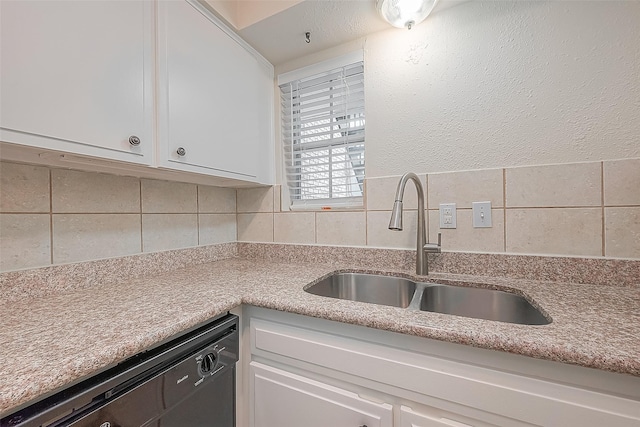 kitchen with white cabinetry, black dishwasher, sink, and decorative backsplash