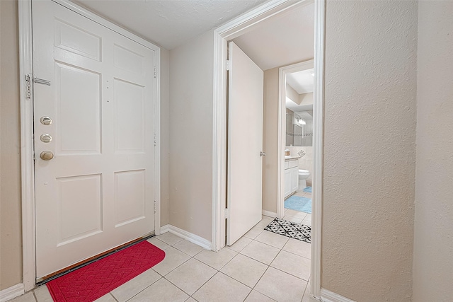 foyer featuring a textured ceiling and light tile patterned flooring