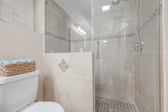 bathroom with toilet and a shower with shower door