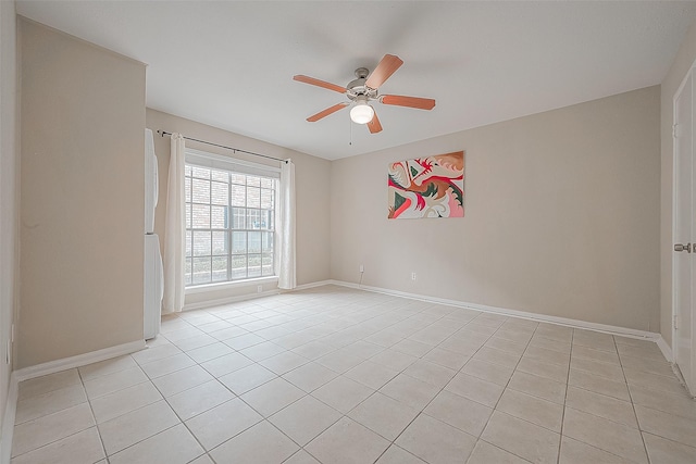 tiled spare room featuring ceiling fan