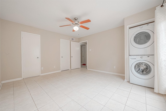 laundry room with stacked washer / drying machine, ceiling fan, and light tile patterned flooring