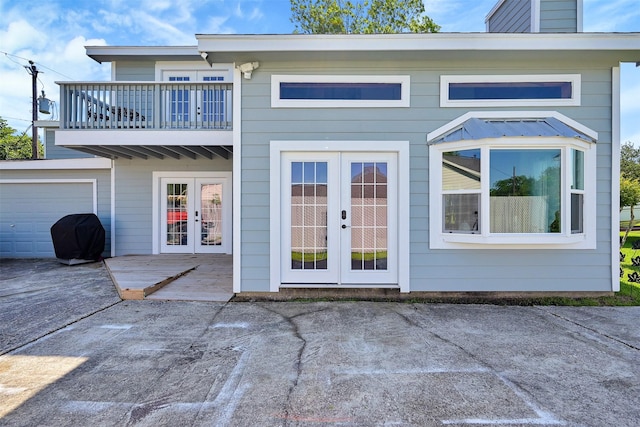 rear view of property with a patio, french doors, and a balcony