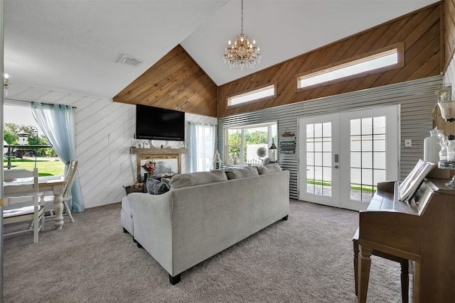 living room featuring a notable chandelier, light colored carpet, french doors, and high vaulted ceiling