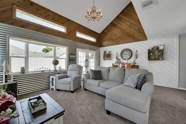 living room with high vaulted ceiling, wood walls, a skylight, carpet flooring, and a chandelier