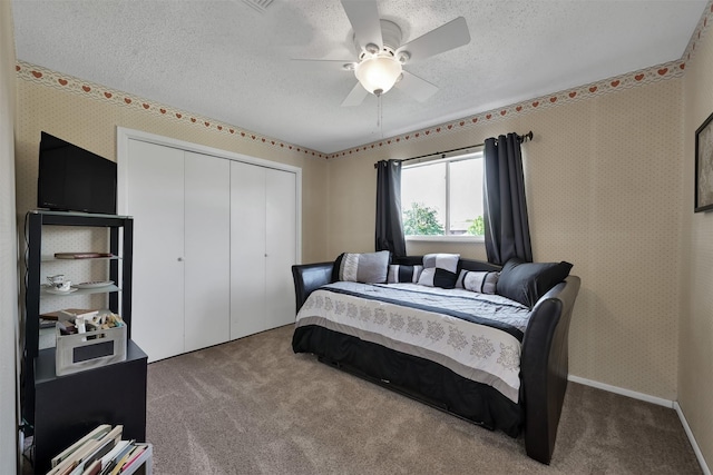 carpeted bedroom featuring ceiling fan, a textured ceiling, and a closet