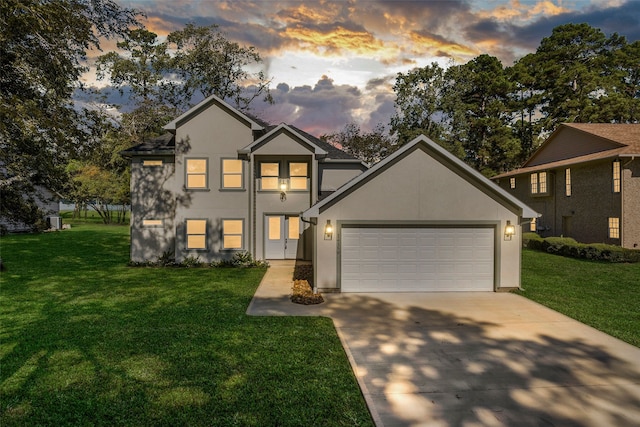 front of property with a garage and a yard