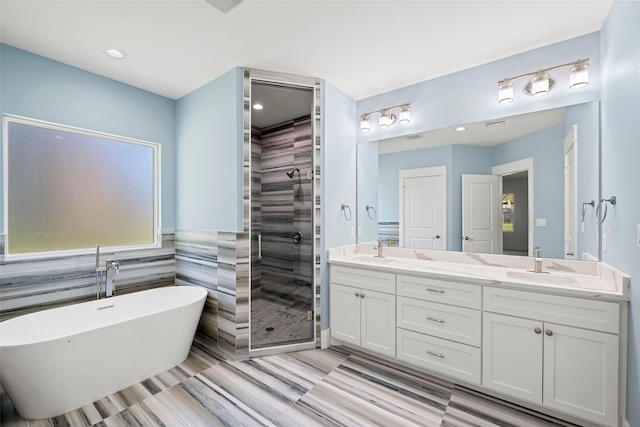 bathroom featuring vanity, separate shower and tub, and tile walls