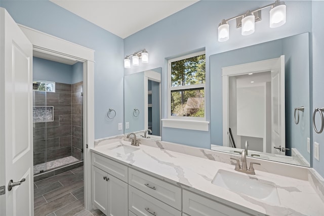 bathroom featuring tiled shower, vanity, and a wealth of natural light