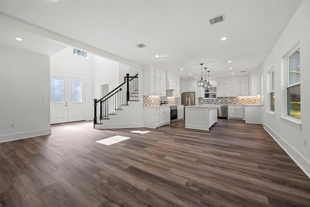 unfurnished living room with dark hardwood / wood-style floors and french doors