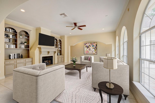 tiled living room featuring plenty of natural light, ornamental molding, and ceiling fan