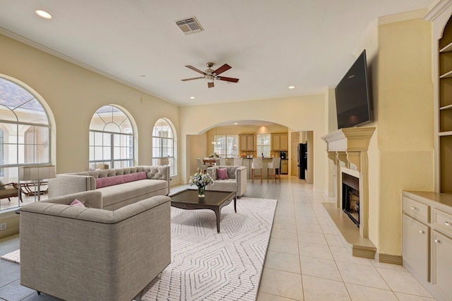 living room featuring crown molding, ceiling fan, and light tile patterned flooring