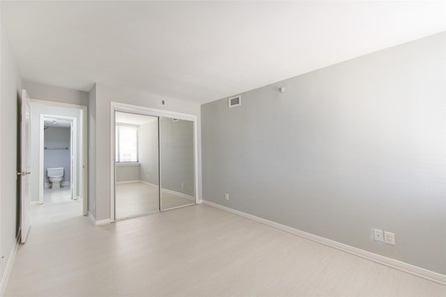 unfurnished bedroom featuring light hardwood / wood-style floors and a closet