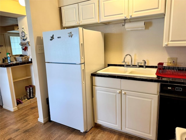 kitchen with sink, tile counters, white cabinets, and white fridge