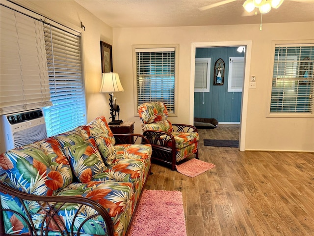 living room with ceiling fan, wood-type flooring, and a textured ceiling